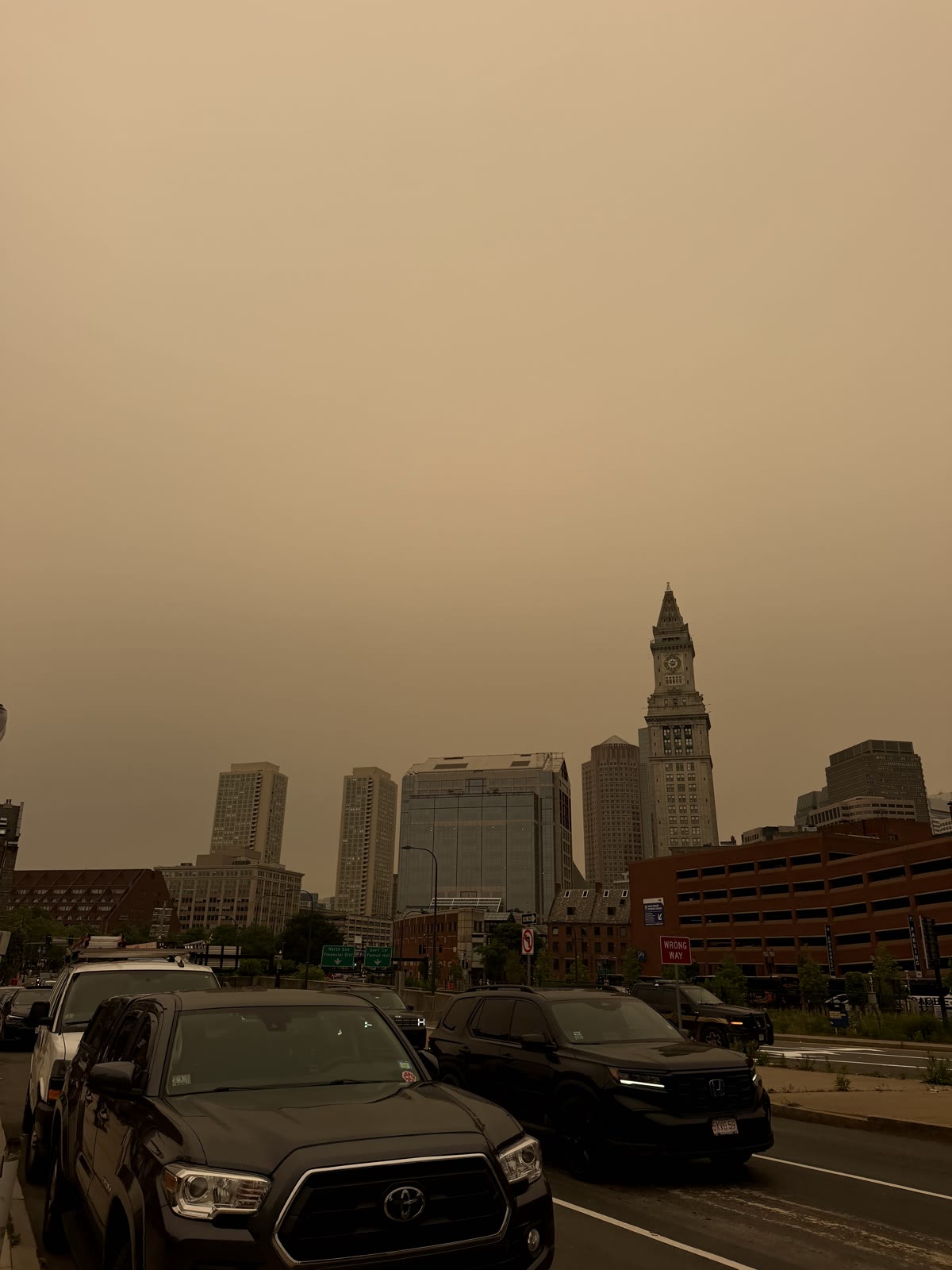 The Custom House clock tower rising over the Boston Financial District, the whole skyline dimmed under wildfire smoke.